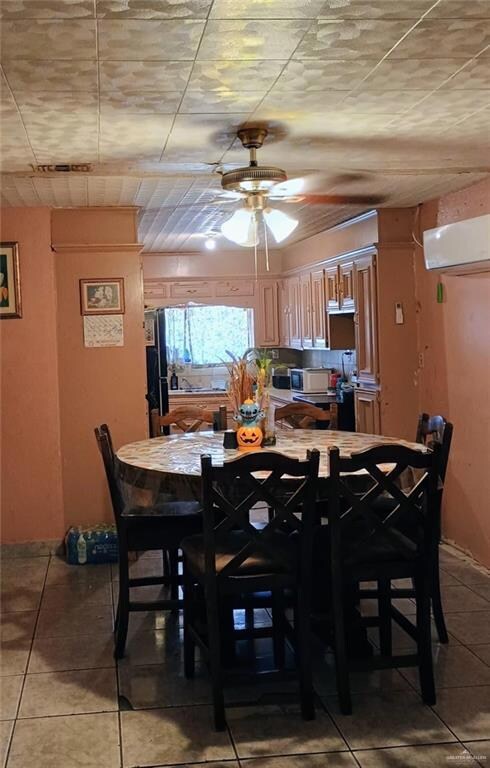 Dining space featuring light tile patterned floors, an AC wall unit, and ceiling fan