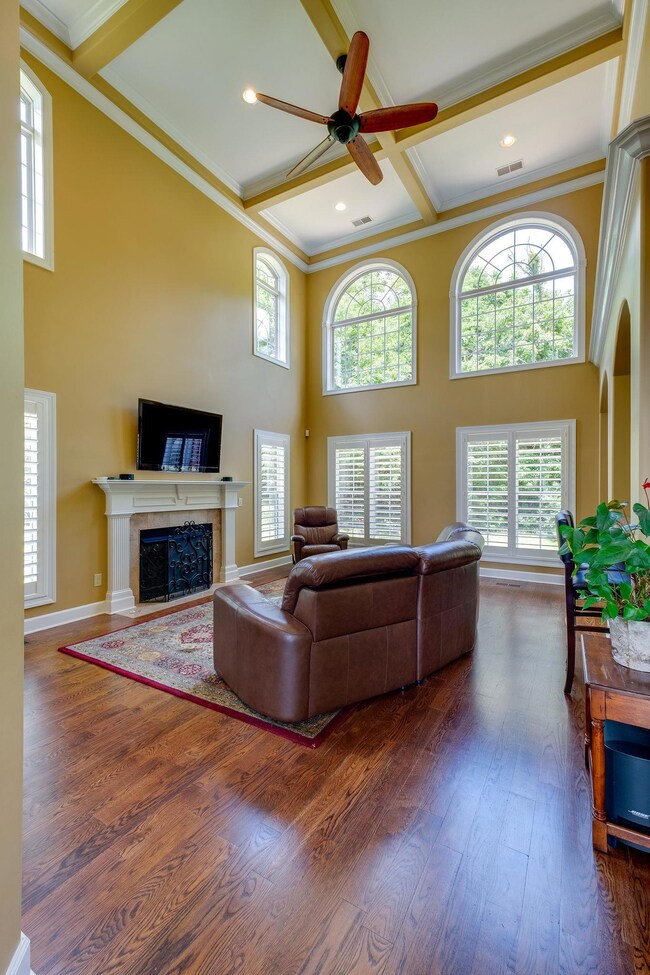 With soaring ceilings and generous space- The Living Room provides a larger and more open living space- a two story space with a gas fireplace, coffered ceilings, and windows across the rear of the home.