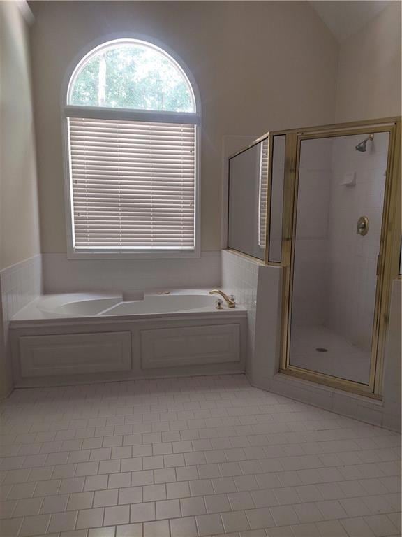 Bathroom with a shower stall and a bath