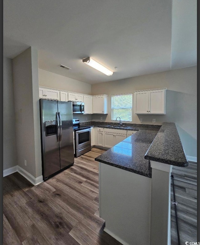 Kitchen with visible vents, dark wood-style floori