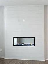 Detailed view of wood finished floors and a glass covered fireplace