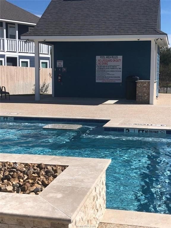 Community pool with fence and a patio area