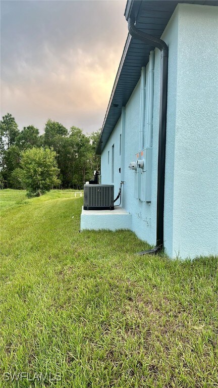 Yard at dusk featuring central AC unit