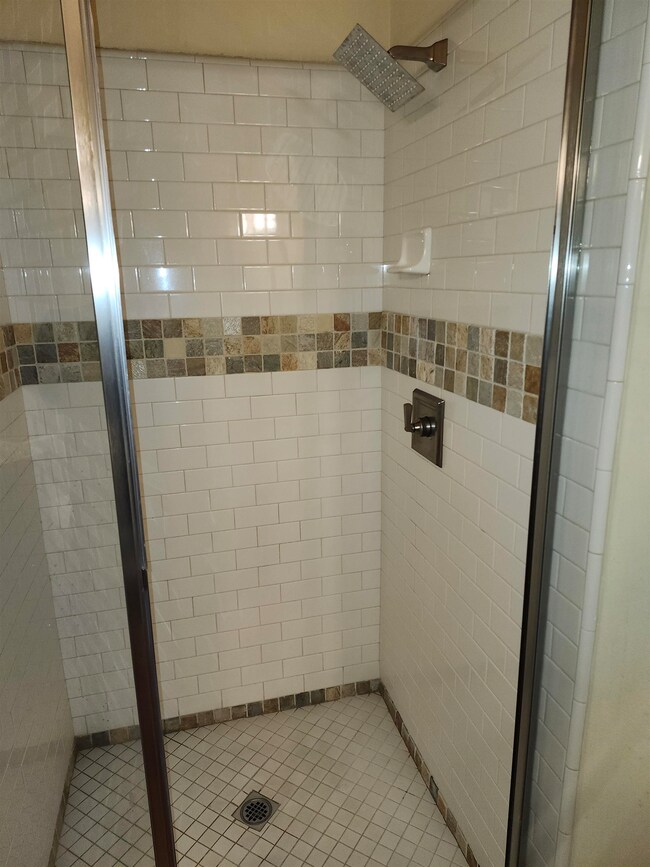 Full bathroom featuring a shower stall