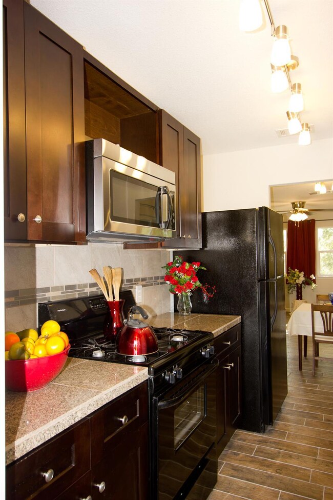 Kitchen with dark wood-style flooring, gas stove,