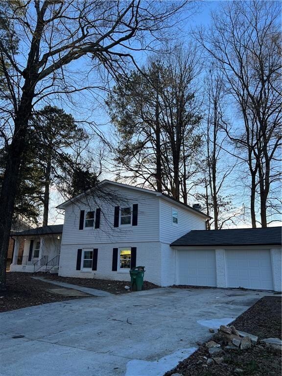 View of side of home with brick siding and concrete driveway