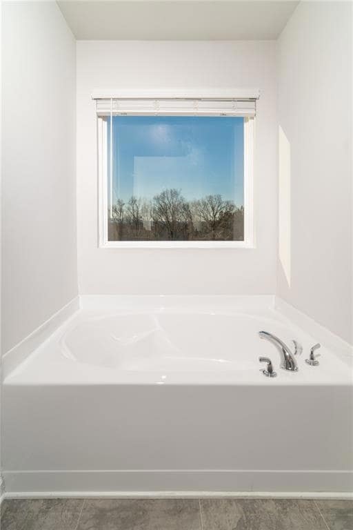 Bathroom with a bath and tile patterned flooring