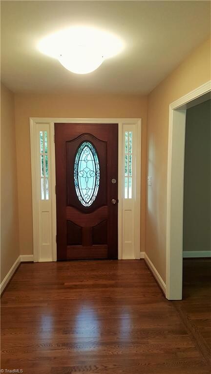 Bright entry with wood flooring and stain glass door!