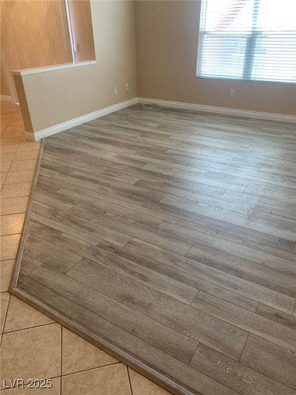 Spare room featuring baseboards and wood finished