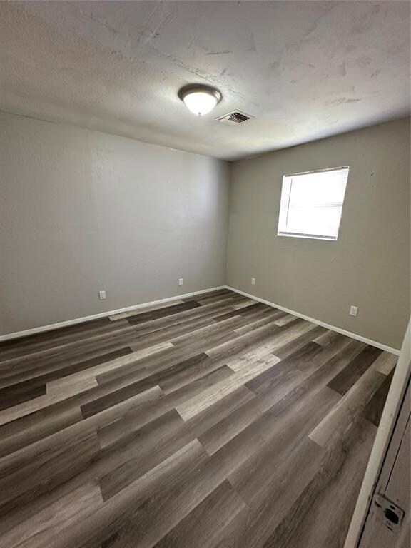 Unfurnished room featuring dark wood finished floo