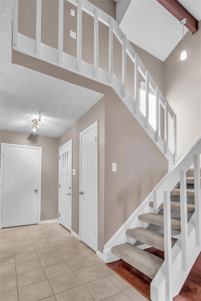 Staircase with tile patterned flooring and beam c