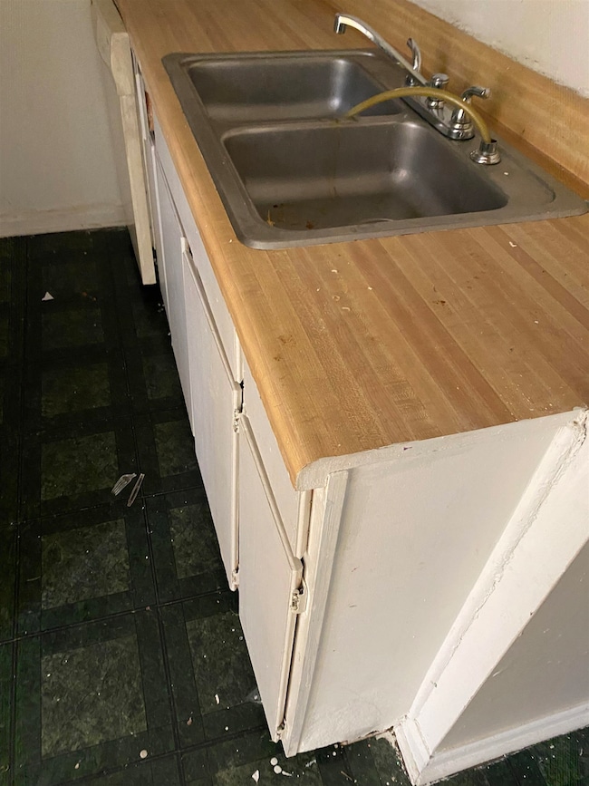Kitchen with white cabinetry, sink, white dishwash
