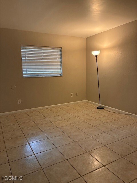 Spare room featuring light tile patterned flooring and baseboards