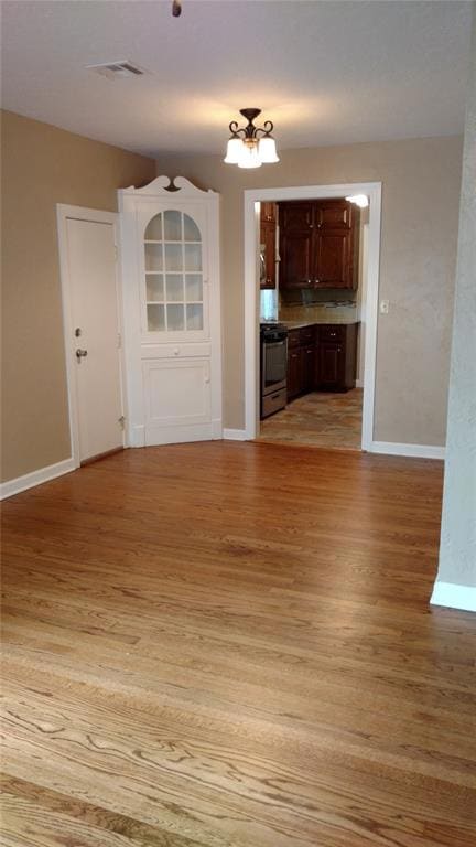 Unfurnished dining area with light wood-style floors and baseboards