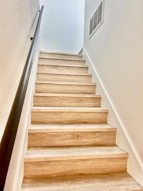 Stairs featuring a textured wall
