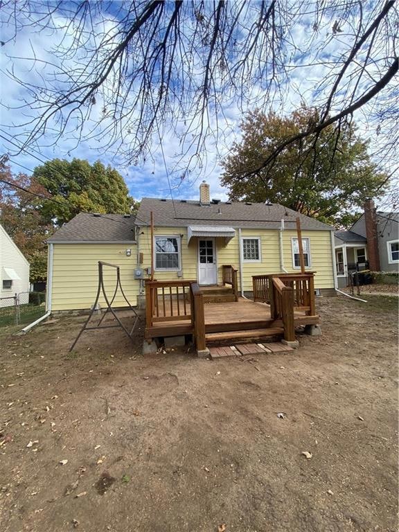 Back of property featuring a wooden deck and a chimney