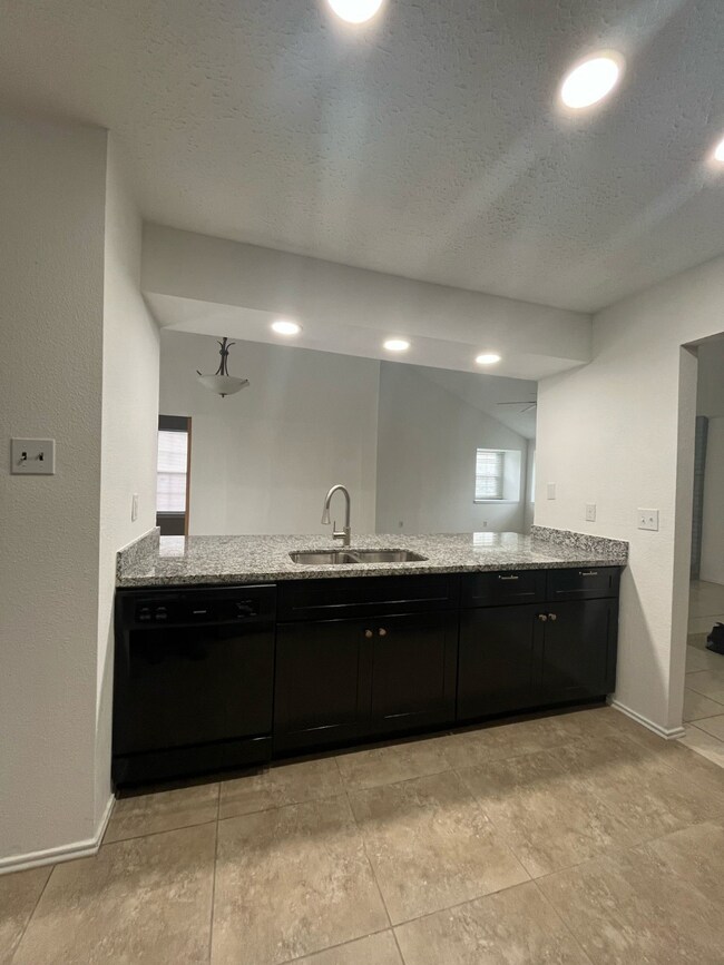 Dishwasher and sink attached to large granite coun
