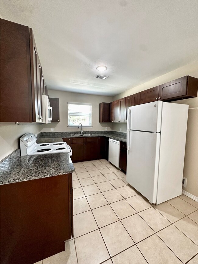 Kitchen with Granite counters and an abundance of cabinetry.
