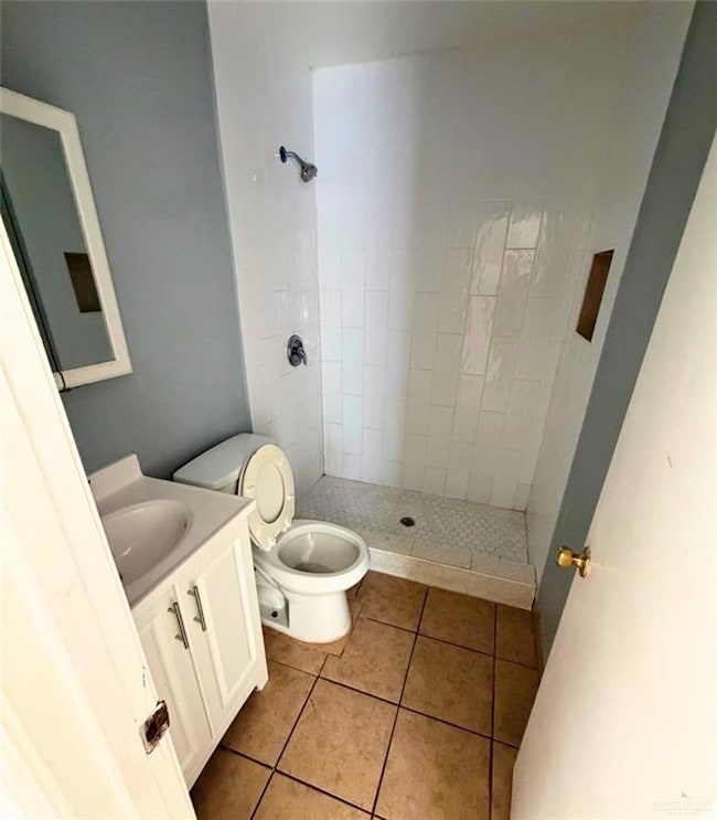 Bathroom featuring a shower stall, vanity, and light tile patterned floors