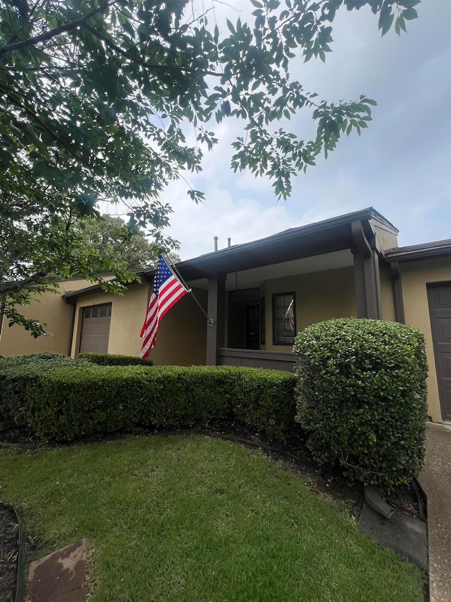 View of front of house featuring a garage, stucco siding, and a front yard