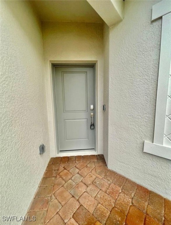 Doorway to property featuring stucco siding