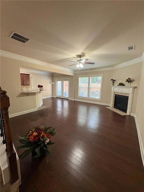 Unfurnished living room featuring crown molding, a ceiling fan, dark wood-type flooring, and a fireplace