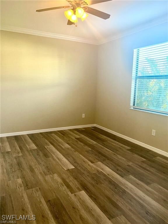 Unfurnished room featuring crown molding, dark woo