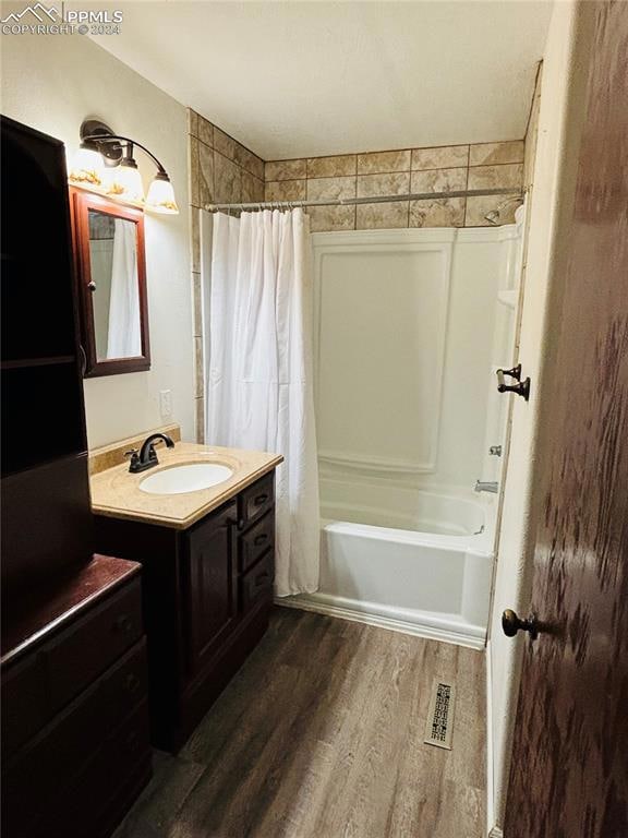 Bathroom with wood-type flooring, vanity, and show
