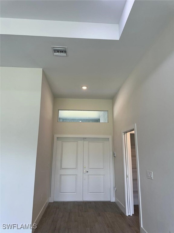 Hall with baseboards, wood finished floors, and re