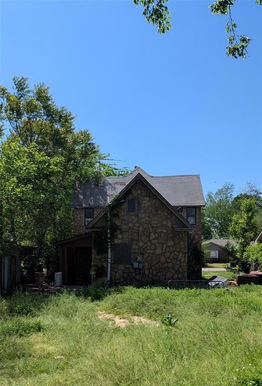 View of side of home featuring stone siding