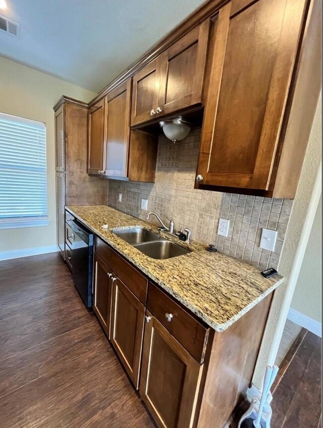 Kitchen featuring black dishwasher, dark wood-typ