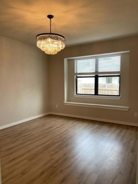 Empty room with baseboards, wood finished floors,