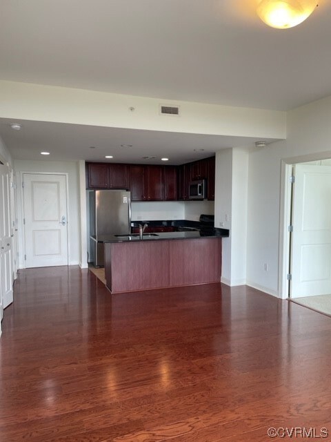 Kitchen with stove, dark hardwood flooring, and re