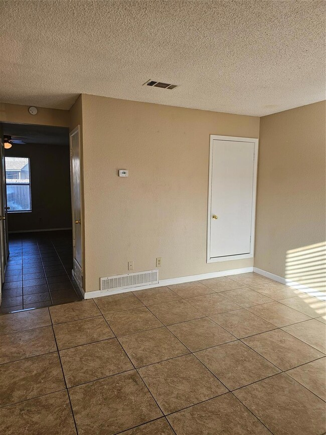 Tiled spare room with a textured ceiling