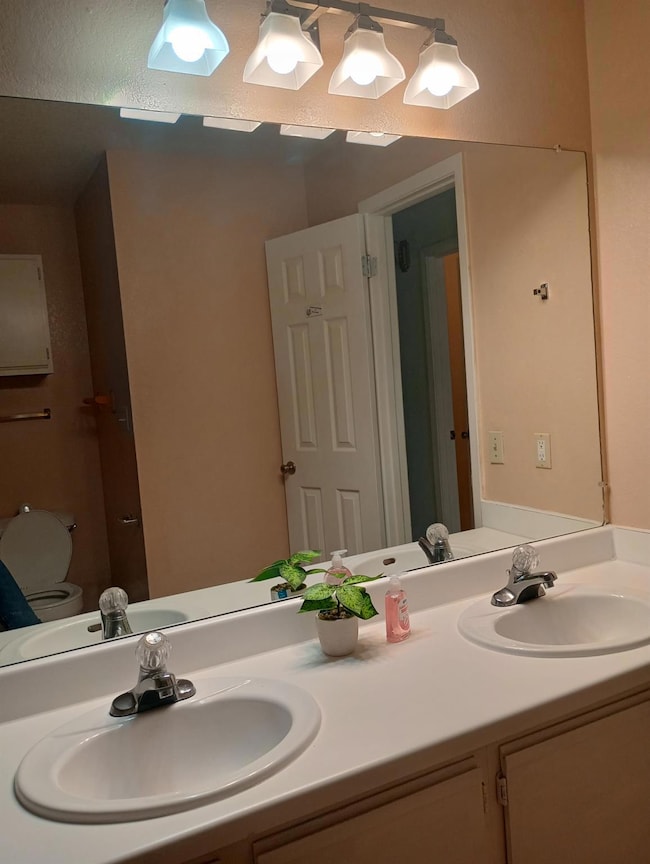 Bathroom featuring double vanity and toilet