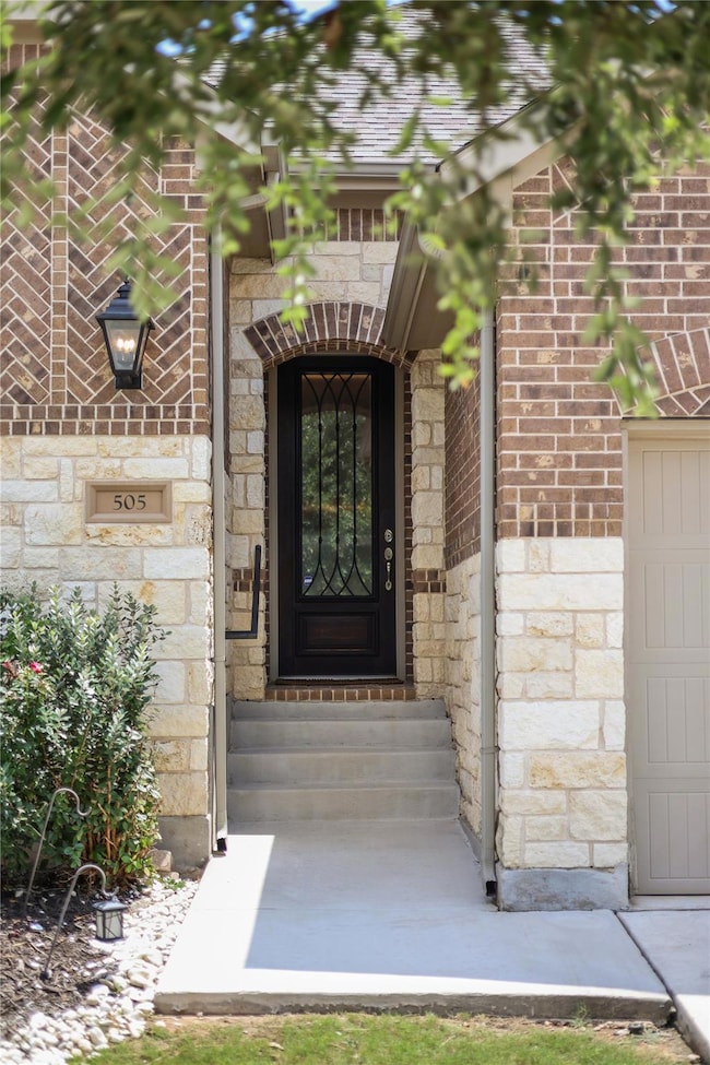Doorway to property featuring stone siding and br