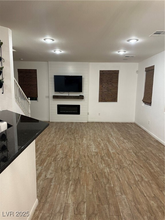 Unfurnished living room featuring wood finished fl