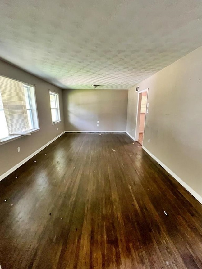 Spare room featuring hardwood / wood-style flooring and baseboards