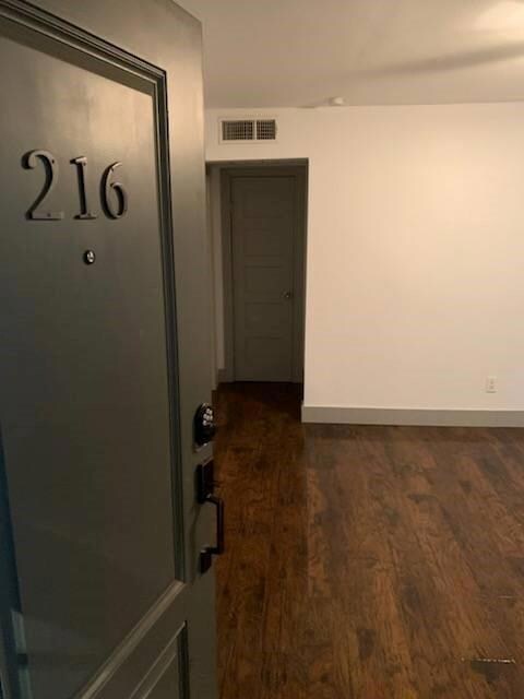 Corridor featuring dark wood-type flooring