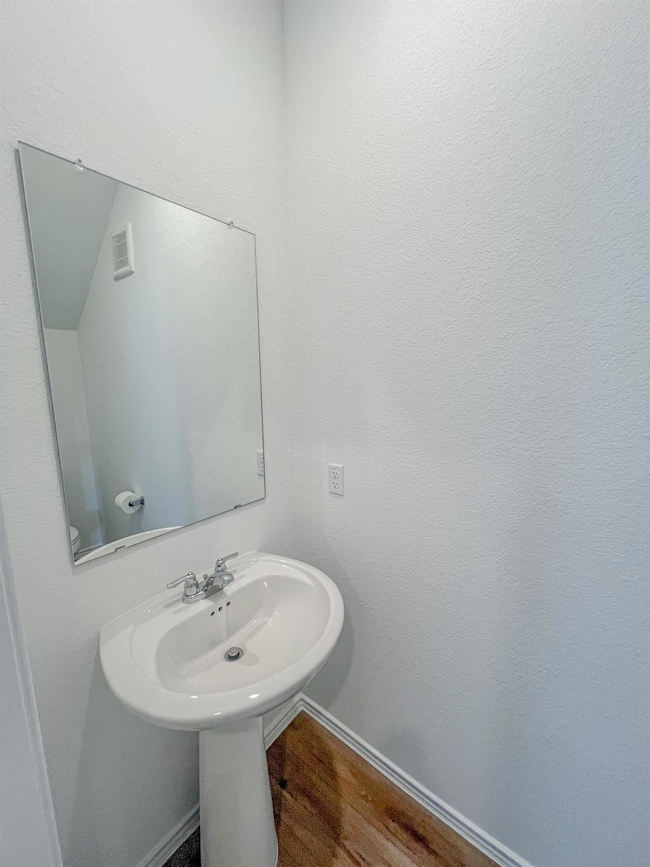 Bathroom with wood finished floors and baseboards