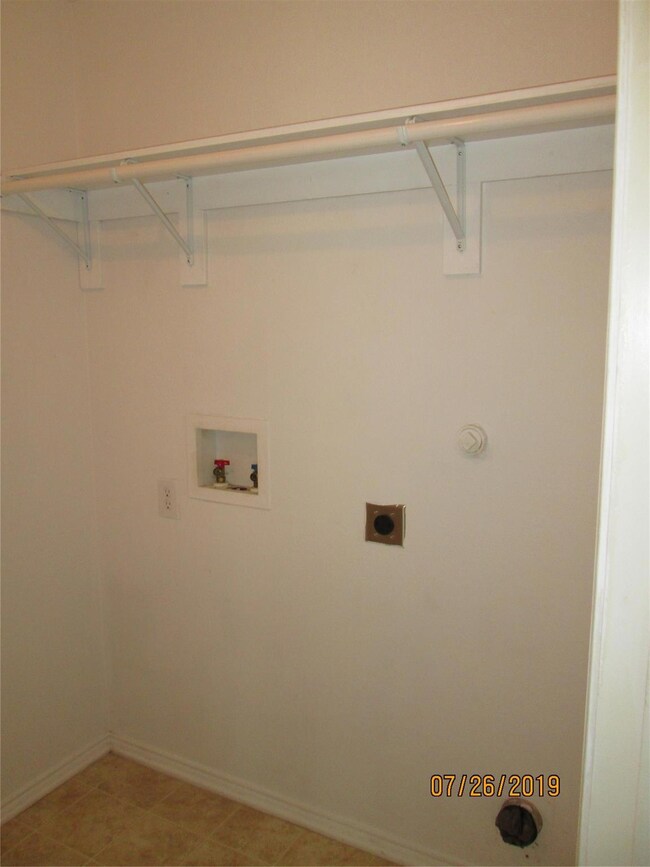 Clothes washing area with electric dryer hookup, washer hookup, and light tile patterned floors