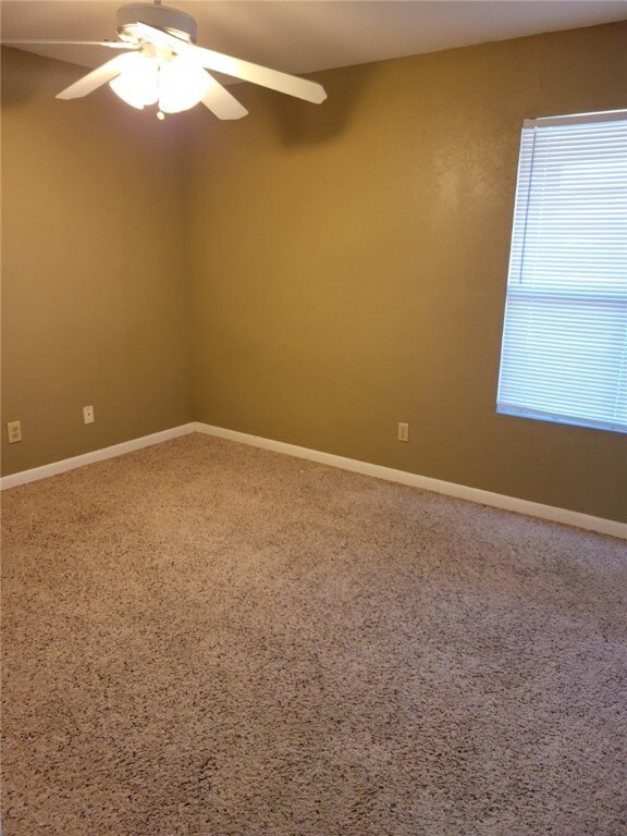Spare room with ceiling fan and carpet