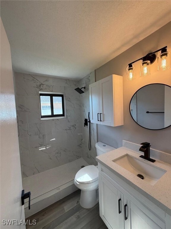 Full bath featuring a textured ceiling, toilet, va