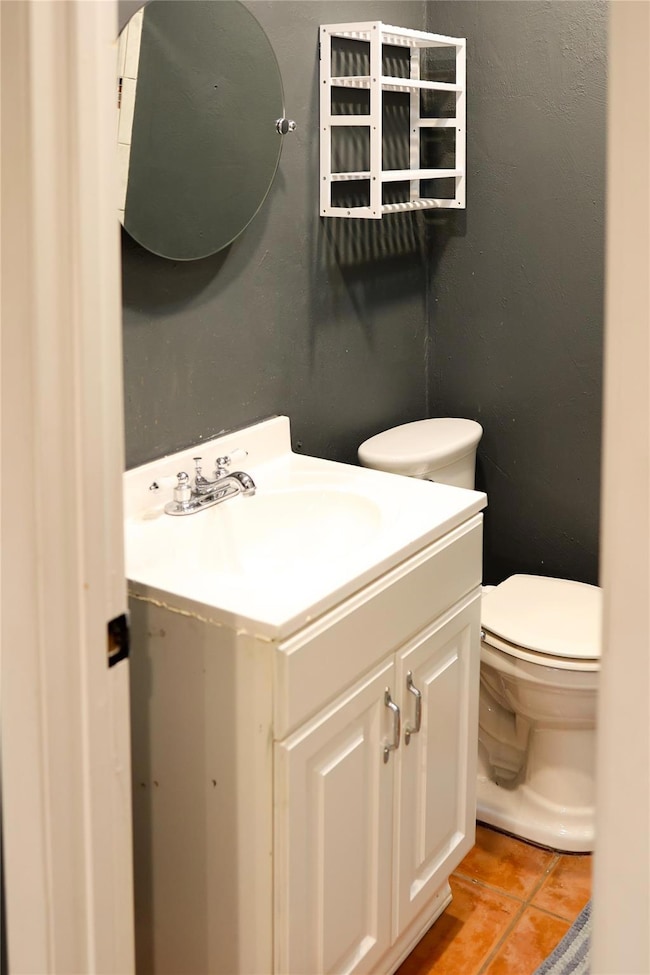 Half bath featuring toilet, tile patterned floors,