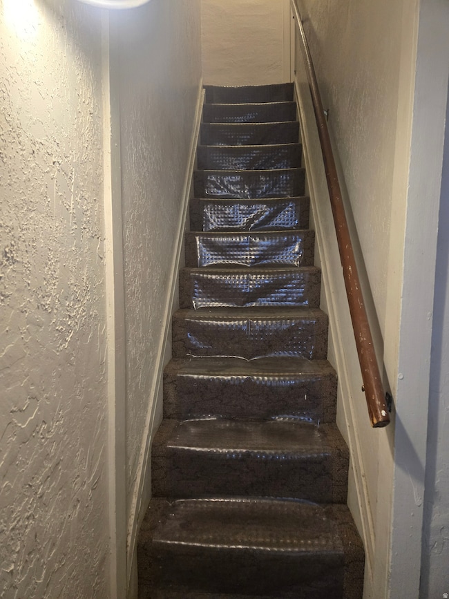 Stairs featuring a textured wall