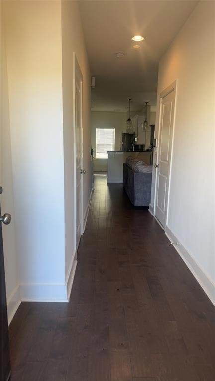 Corridor with baseboards and dark wood-style flooring