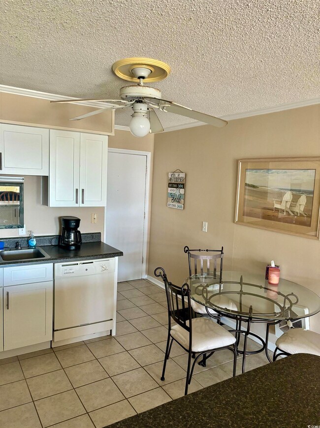 Kitchen featuring white dishwasher, ceiling fan, a textured ceiling, and white cabinets