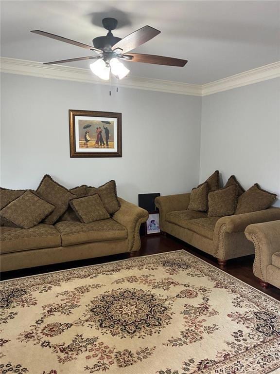 Living room with crown molding, a ceiling fan, and wood finished floors