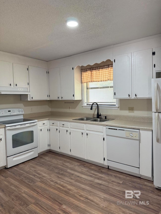 Kitchen featuring white appliances, a textured ceiling, white cabinetry, recessed lighting, and dark wood-style flooring