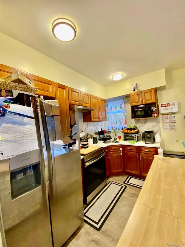 Kitchen with stainless steel appliances, wood counters, tasteful backsplash, and under cabinet range hood